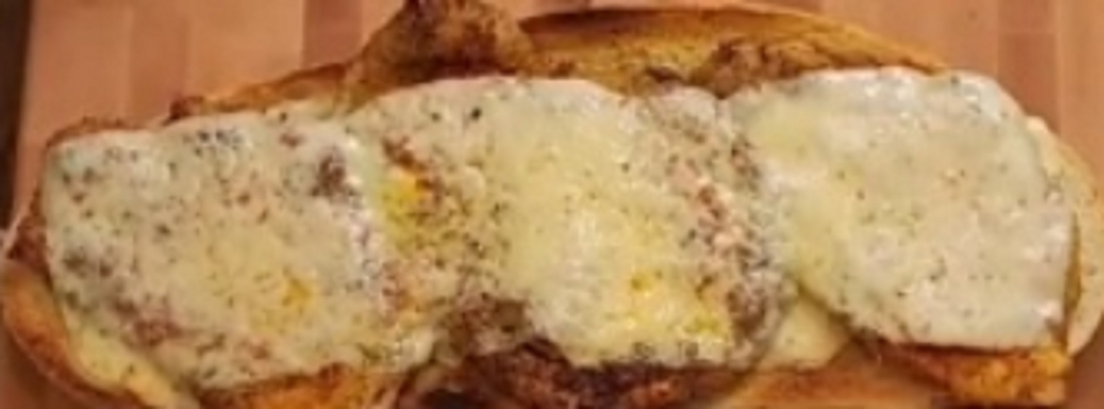 Recette: Escalope de poulet gratine sur un pain au four.